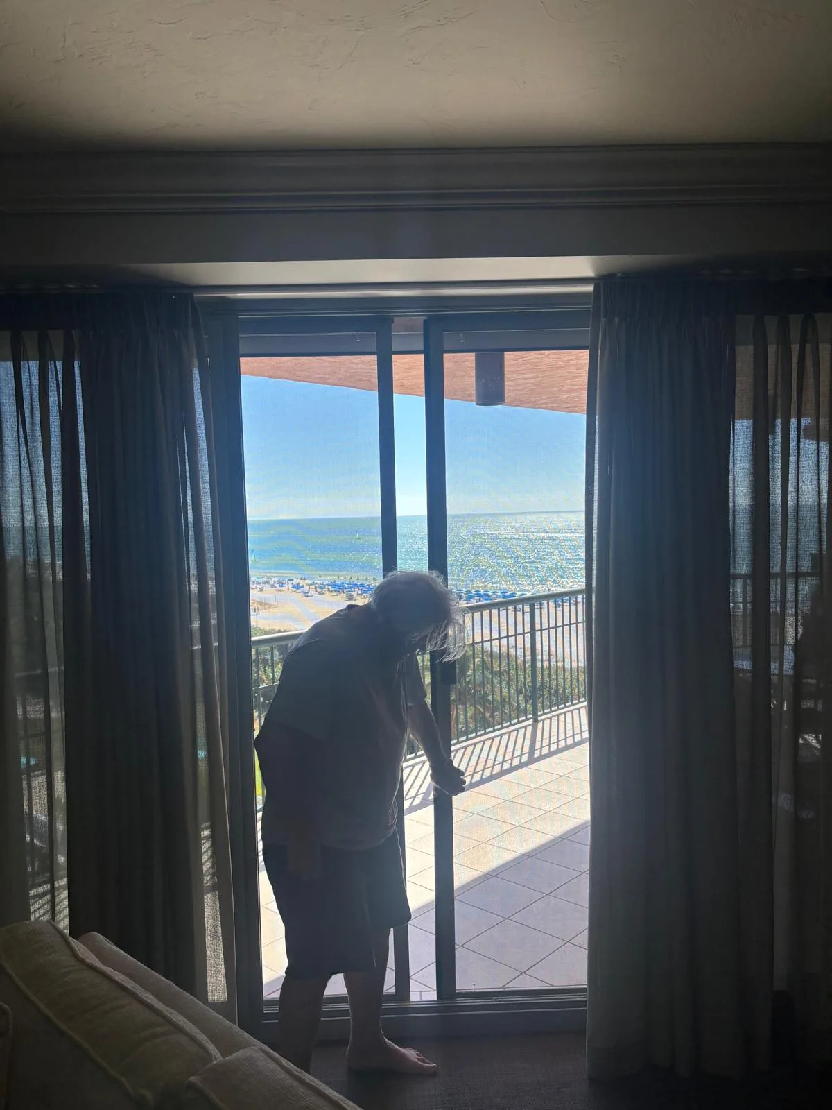 A homeowner straining to slide a heavy, hard-to-open patio door