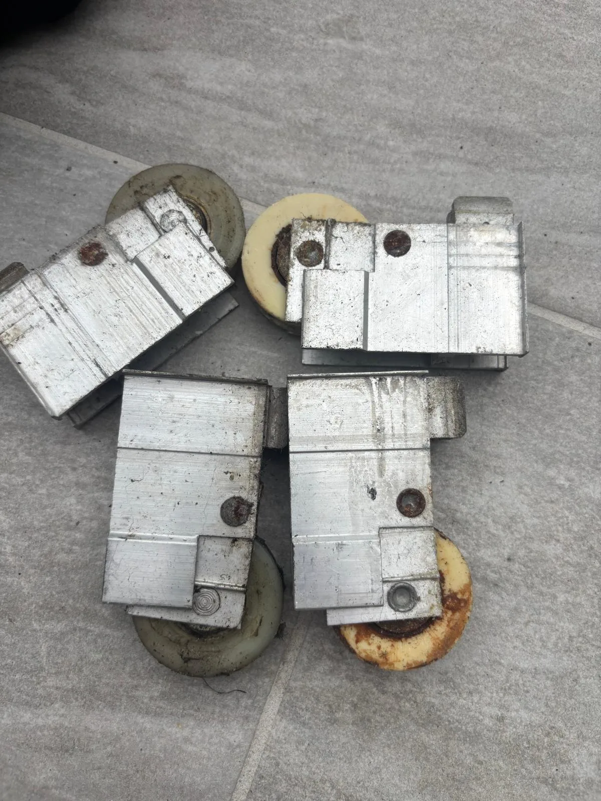 Four worn roller assemblies extracted from a sliding glass door during a replacement job